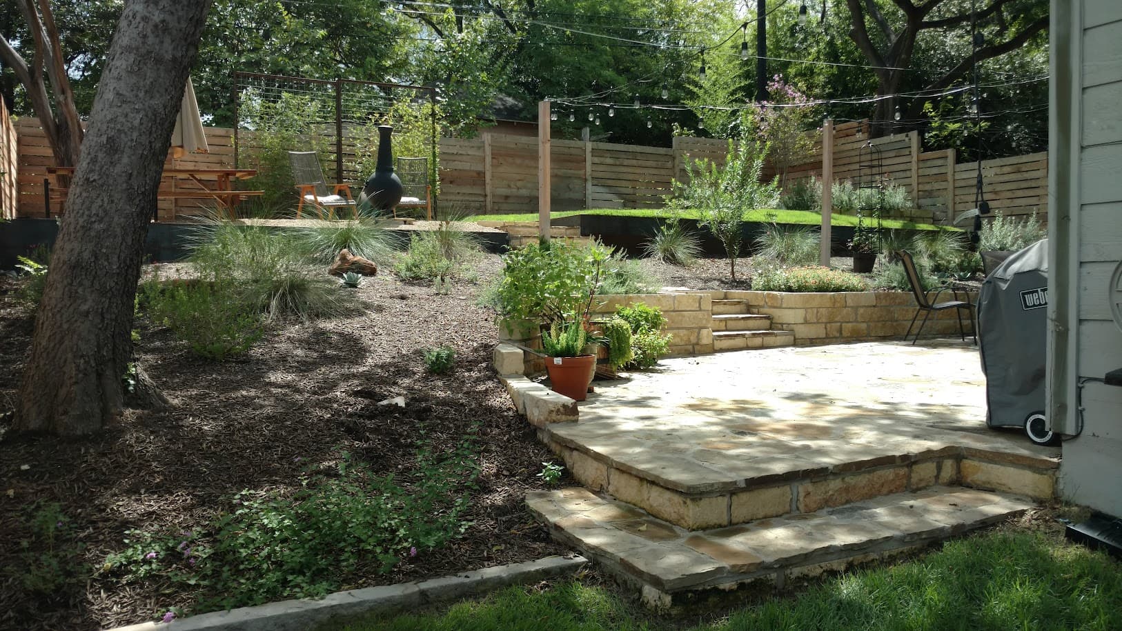 Kellison project, limestone patio with custom seating wall and drought-tolerant native plantings